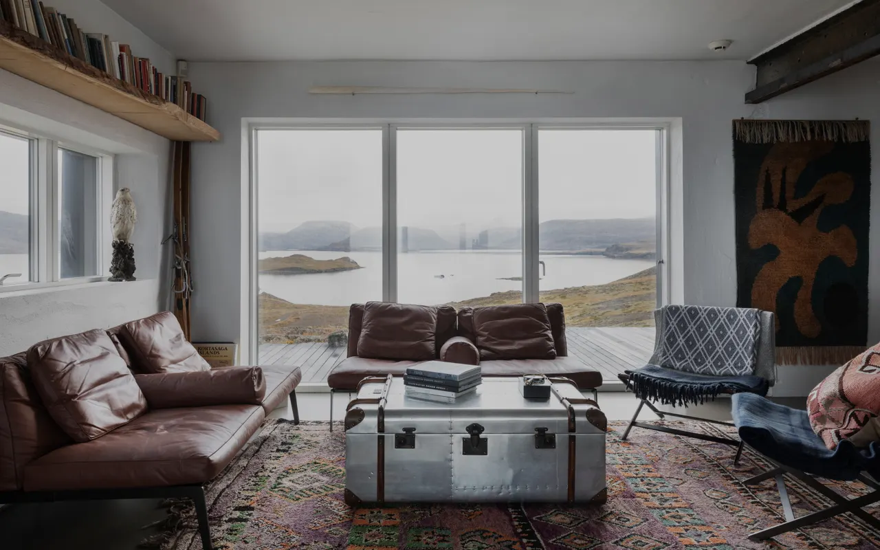 Living room in the Hilltop House with leather sofas and fjord views